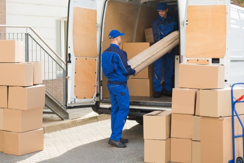 Movers in Wimbledon loading furniture into a van on a residential street